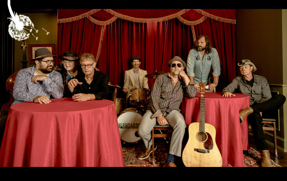 Wishgarden band at round tables with red tablecloths in front of ornately curtaned stage.