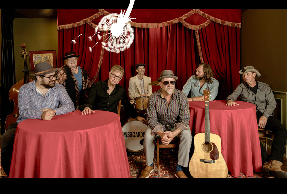 Wishgarden band at round tables with red tablecloths in front of ornately curtaned stage.