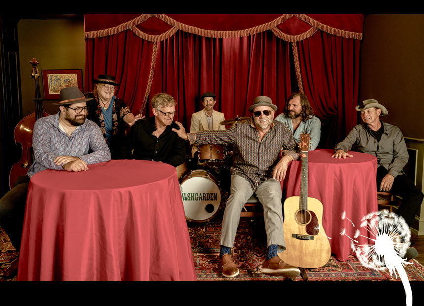 Wishgarden band at round tables with red tablecloths in front of ornately curtaned stage.
